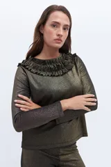 Remera de manga larga confeccionada en tejido de lurex negro con destellos dorados y volados en el cuello.