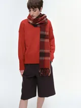 Buzo tejido de corte oversize en color rojo, con cuello redondo, hombros caídos y puños y bajo acanalados.