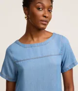 Vestido corto de liocel color azul oscuro, con cuello redondo, mangas cortas y recortes decorativos en el pecho.