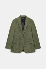 Blazer de Zara Woman Collection confeccionado en hilatura con lana, de color verde con diseño de espiga y motas de colores. Presenta cuello solapa, manga larga con botones, bolsillo de vivo en el pecho y bolsillos delanteros con solapa. Cierre frontal con botones.