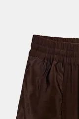 Pantalón de tiro medio con cintura elástica ajustable con cordón. Presenta un diseño de paneles laterales en tejido técnico contrastante y bolsillos tipo cargo. Su corte es holgado con pernera que se estrecha hacia el tobillo.