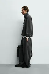 Pantalón de corte baggy fit confeccionado en tejido técnico, con cintura elástica ajustable mediante cordón y bajo con elásticos laterales para ajuste.