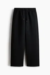 Pantalón tipo jogger de corte relajado con efecto neopreno, cintura elástica con cordón ajustable, bolsillos laterales al bies y bolsillo de parche en la parte trasera.