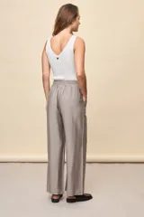 Pantalón gris de corte amplio y silueta fluida, con cintura elástica y cordón ajustable.
