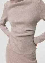 Jersey de cuello alto y manga larga, confeccionado en tejido suave de punto color tostado, con diseño de corte recto y holgado.