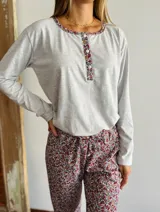 Pijama de algodón gris con estampado floral, compuesto por una camisa de manga larga con botones y un pantalón largo con cintura elástica.