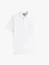 Chomba blanca de corte regular confeccionada en algodón orgánico con un toque de elastano, cuello tipo chomba y cartera de dos botones. Tiene el logo de Tommy Hilfiger bordado en el pecho.