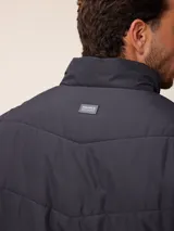 Campera acolchada de nylon color azul, con cierre frontal, cuello alto y logo de la marca bordado en el pecho.