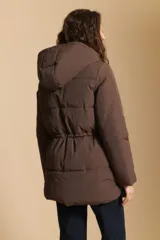 Campera acolchada de nylon en color crema, con capucha ajustable, cierre frontal con botones y cordón de ajuste en la cintura.