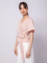 Blusa verde agua con textura acanalada, escote en V, mangas cortas amplias y lazo para atar en la cintura.