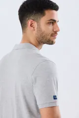 Remera polo lisa de piqué en color bordó, con cuello camisero, cierre frontal con botones y mangas cortas.