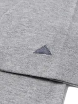 Remera tipo polo de manga corta, color gris melange, con cuello y puños acanalados. Presenta el logo de la marca estampado en el pecho y un pequeño bordado triangular en la manga.