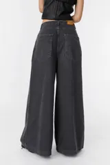 Jean de corte wide leg en color bordó, confeccionado en denim de algodón. Presenta tiro medio, bolsillos traseros amplios y una silueta holgada y fluida.