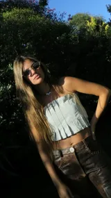 Top strapless de cuero metalizado color dorado, con diseño de tablones verticales en el frente que aportan estructura y elástico en la espalda para un ajuste cómodo.