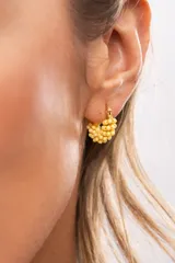 Aro de acero quirúrgico en formato argolla pequeña, recubierto con cuentas tipo mostacilla de color amarillo.