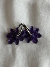 Aros de argolla metálica con dije colgante en forma de flor de acrílico color rosado.