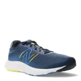 Championes de running New Balance, color azul marino con detalles en amarillo neón. Presentan una capellada de malla transpirable, cierre con cordones y una entresuela blanca con suela de goma bicolor.