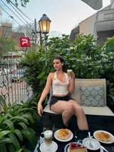 Top corto negro con escote drapeado y espalda descubierta.