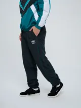 Pantalón de jogging Umbro color azul marino, de corte recto, con cintura elástica y líneas blancas decorativas a los laterales. Presenta el logo de la marca bordado en blanco en la pierna izquierda.