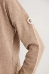Buzo de escote en V y manga larga, confeccionado en lana lambswool. Presenta un diseño básico con detalle de raya en contratono en una de las mangas, puños y ruedo en color contrastante, y pin metálico de la marca aplicado en la manga.