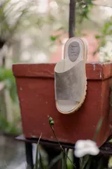 Sandalia tipo chinela de cuero marrón con textura granulada, plantilla de cuero y suela de madera con base de goma.