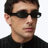 Lentes de sol Titi All Black con armazón ovalado alargado de acetato negro brillante y lentes oscuros polarizados.