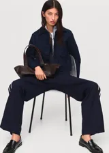 Pantalon de vestir de corte recto y tiro medio, color azul marino. Presenta cintura elástica con lazo ajustable y una raya lateral en contraste de color blanco.