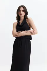 Musculosa negra con detalle drapeado, cuello bote y espalda descubierta.