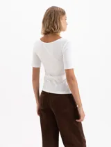 Remera negra de poliamida con elastano, de calce ajustado, con escote redondo amplio y mangas cortas al codo.