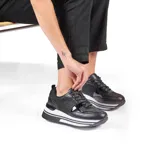 Zapatillas urbanas negras con detalles de charol y glitter, plataforma blanca con rayas horizontales negras.