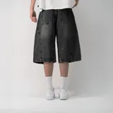 Bermuda de jean estilo baggy en color negro lavado, con corte holgado, tiro medio y cierre frontal con botón y cremallera.
