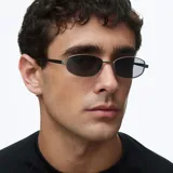 Lentes de sol con montura rectangular de acero inoxidable en color gris mate y lentes polarizadas negras. Presentan un diseño minimalista con varillas metálicas y terminales de acetato.