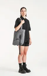 Bolso tipo tote bag de microfibra técnica color gris, con cordón ajustable con tanca. Posee un bolsillo externo con velcro y un bolsillo interno con cierre.