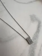 Collar de acero quirúrgico plateado con dije de letra F incrustado de strass.