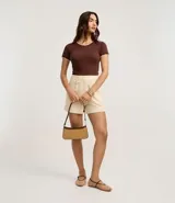 Top de manga corta ajustado al cuerpo, color marrón oscuro, con cuello redondo y bordes festoneados en color crema o beige claro.