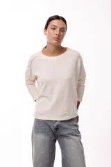 Remera de silueta relajada, confeccionada en tejido de punto, con cuello redondo, mangas largas y un bolsillo aplicado en el frente.