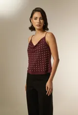 Musculosa negra de poliéster con cuello buche, breteles finos y apliques de tachas metálicas en toda la parte frontal.