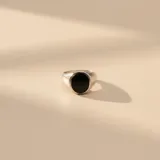 Anillo tipo sello de plata 925 con centro circular de resina negra, diseño minimalista y elegante.