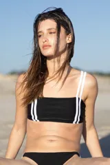 Top de bikini negro con escote recto, breteles elásticos blancos y doble tira en la espalda.