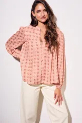 Blusa de corte oversize con estampado de abanicos, cuello redondo con pequeña abertura frontal, cierre de botones y mangas largas con puños elásticos.
