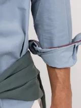 Camisa de micropana celeste para hombre, de corte regular fit y manga larga. Cuenta con cuello abotonado, cierre frontal con botones y detalle de vivo liso en el interior de los puños.