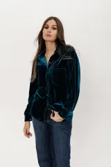 Camisa de terciopelo color petróleo, con corte estilo jean, bolsillo en la parte delantera y botones símil metal color oro viejo.