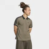 Chomba Adidas de manga corta en color verde militar, con cuello polo negro de bordes amarillos y cierre frontal parcial. Cuenta con las clásicas tres tiras en los hombros y mangas, y el logo del trifolio bordado en el pecho.