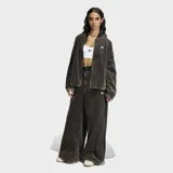 Pantalón de corte holgado confeccionado en tejido de corderoy, con diseño de cintura alta y cierre frontal con botones. Presenta una estética urbana con franjas laterales características de la marca.