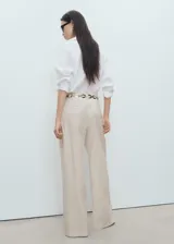 Pantalón wide leg de tiro medio con diseño de rayas sutiles, pinzas delanteras, bolsillos laterales y de ribete en la parte posterior. Cuenta con cierre de gancho y cremallera, y trabillas para cinturón.