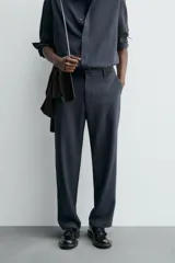 Pantalón de corte relaxed fit, con cintura ajustable, bolsillos delanteros y bolsillo trasero de plastrón. Presenta cierre frontal con cremallera y botón.