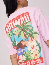 Remera de corte oversized, color amarillo, con cuello redondo y mangas cortas. Presenta un estampado gráfico pequeño en la parte inferior delantera.