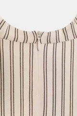 Vestido corto de cuello subido y sin mangas, con diseño fluido y pliegues en los hombros. Presenta un detalle de frunces en el frente, una abertura lateral y un borde inferior decorado con encaje negro en contraste.