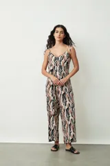 Monoprenda (jumpsuit) de mujer con estampado abstracto en tonos negro, marrón y blanco. Presenta escote en V, tirantes finos ajustables y pierna ancha tipo palazzo.