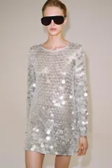 Vestido corto de punto con cuello redondo y manga larga, completamente cubierto de lentejuelas brillantes y perlas decorativas.